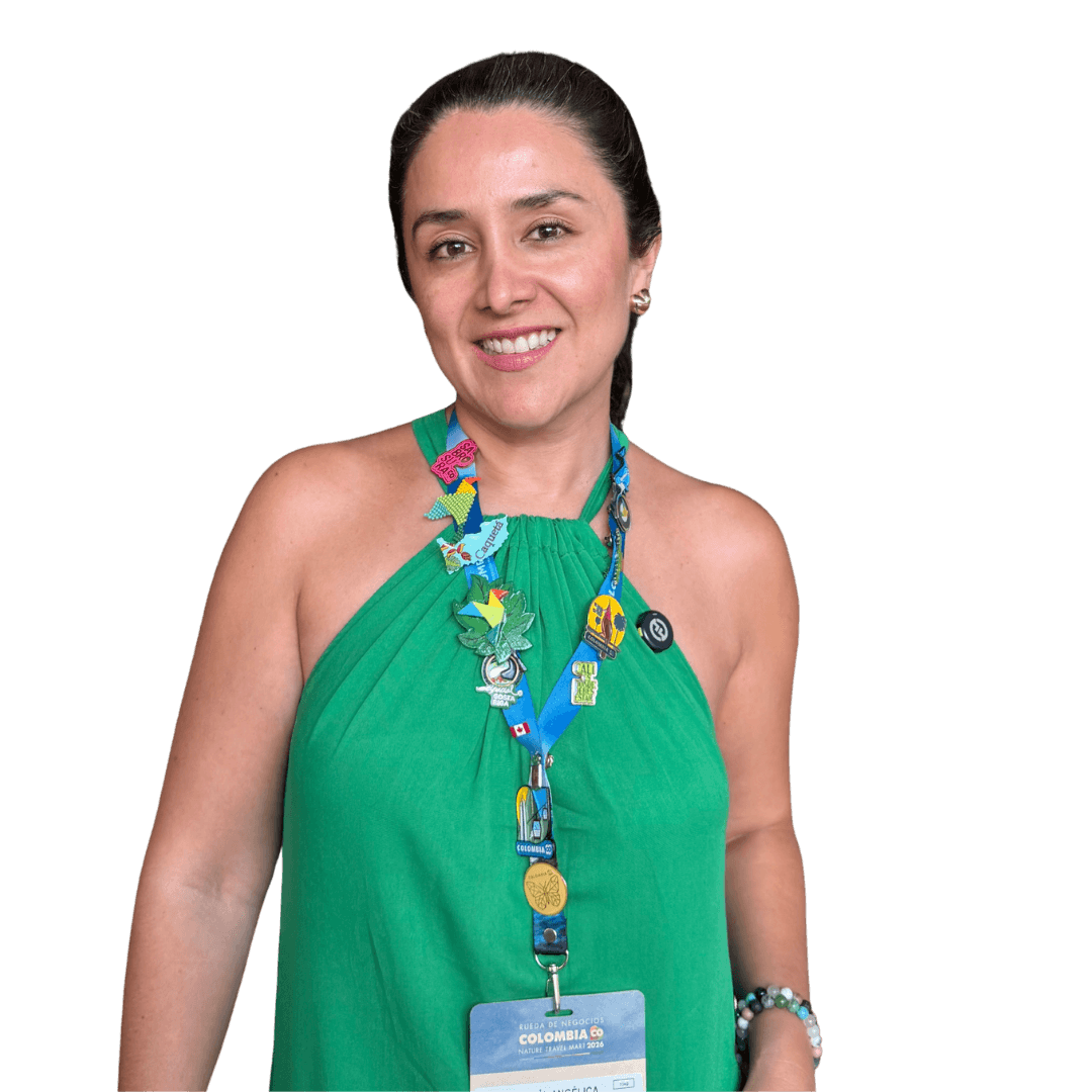 Mujer sonriente de blusa verde, con la escarapela de un evento al cuello.