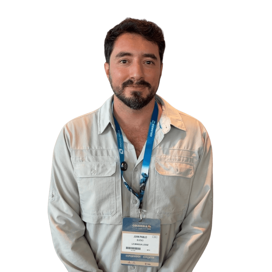 Hombre de barba y camisa clara, con la escarapela de un evento.
